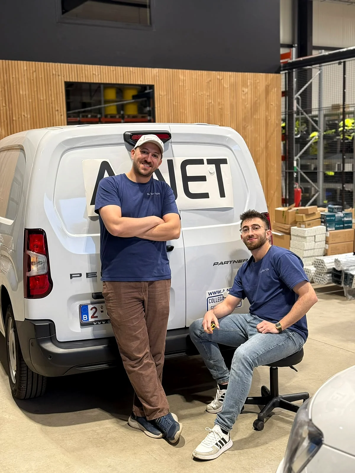 Het team van Slash Design in het atelier, bij een net beletterde bestelwagen